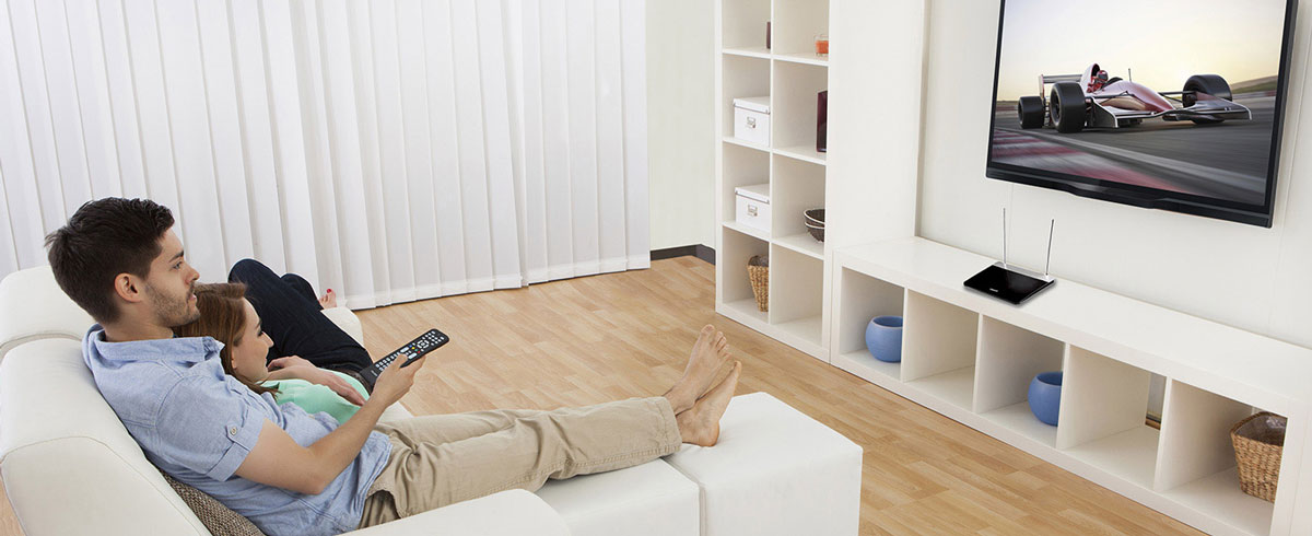 Kanepede oturmuş televizyon izleyen adam ve kadın