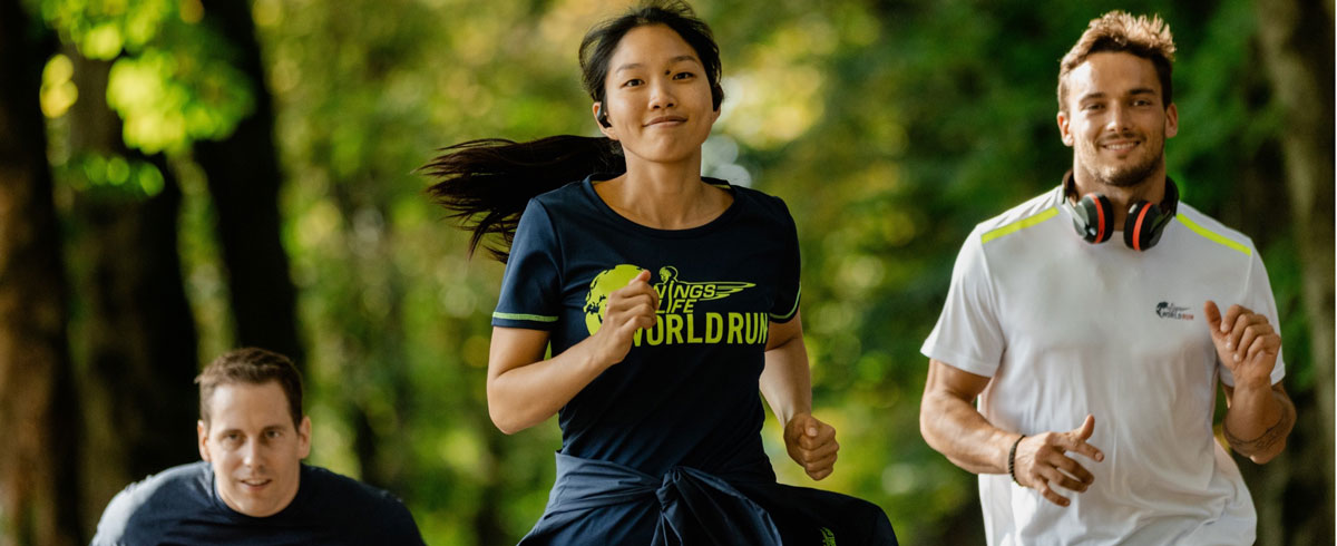 &Uuml;&ccedil; Wings for Life World Run katılımcısı, Philips spor kulaklıkları ile neşeli şekilde koşuyor.